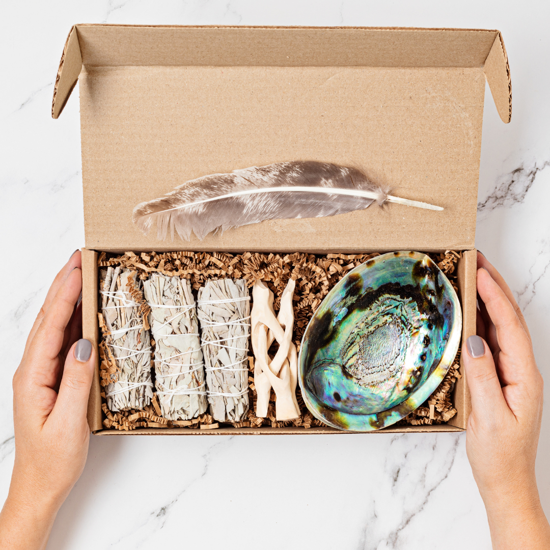 two hands holding a box with an assortment of items in it